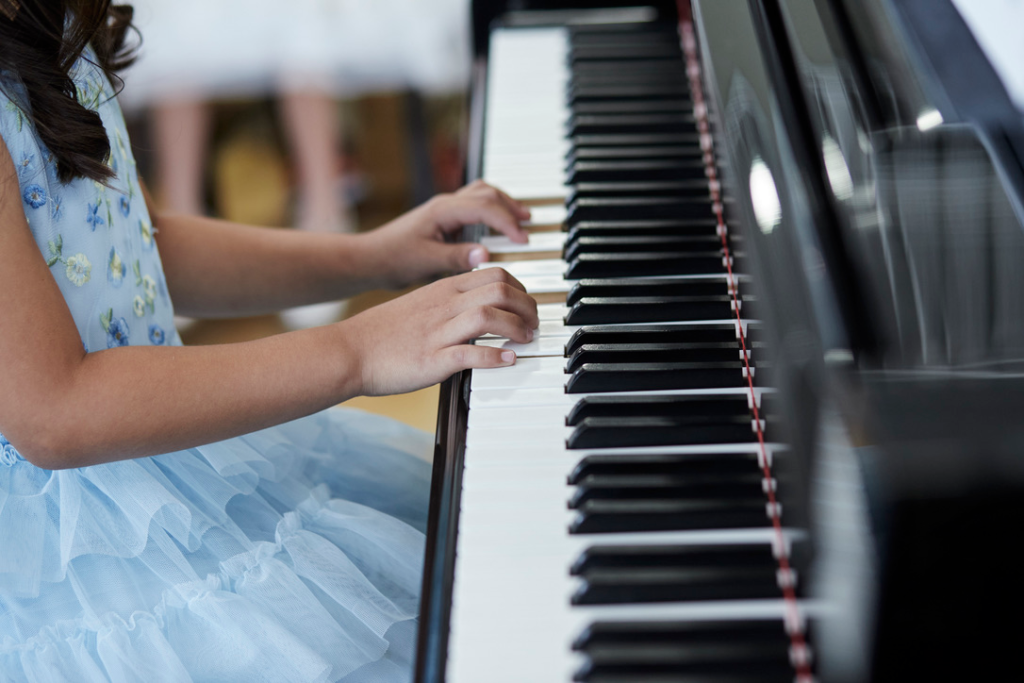 Piano student hands on the piano