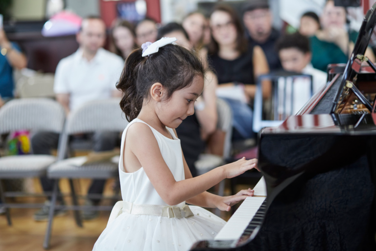 Young piano student performing at piano recital
