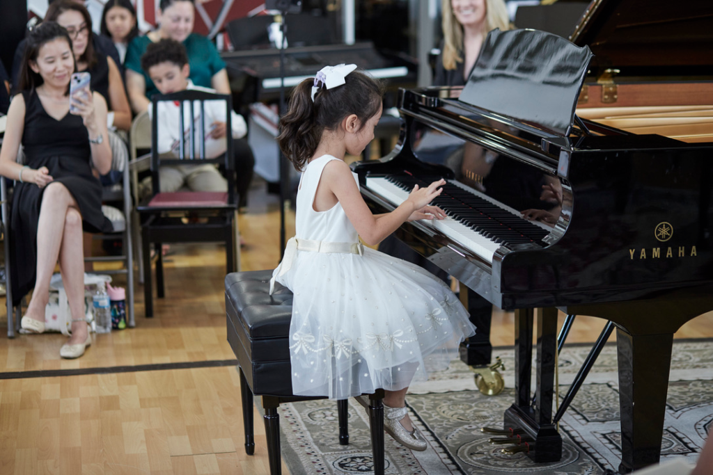 Young pianist performing at piano recital