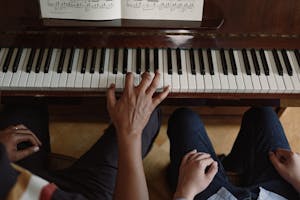 A close-up view of hands playing piano, focusing on music education and practice.