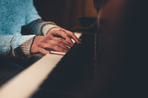 Person practicing piano in cozy warm lighting