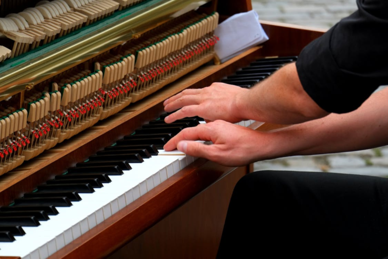 Hands playing piano keys in soft light