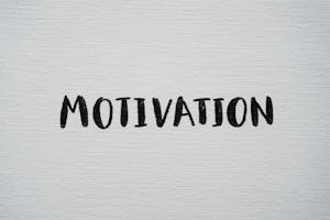 Inspirational word 'Motivation' in black on a white textured canvas background.