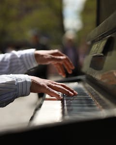 An outdoors close-up photo showing hands playing the piano.