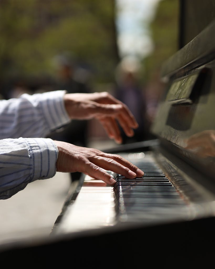 An outdoors close-up photo showing hands playing the piano.