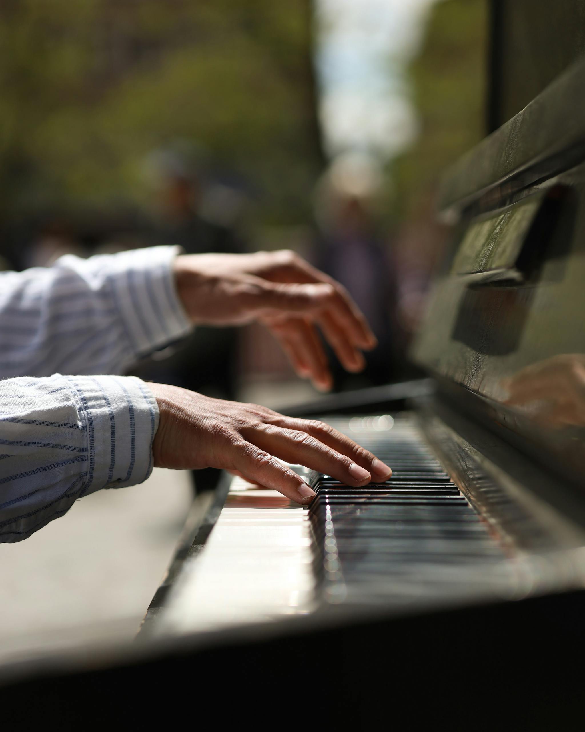 An outdoors close-up photo showing hands playing the piano.