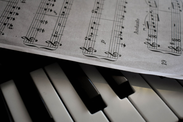 Close-up of piano keys and sheet music, illustrating what to look for when choosing a piano or keyboard for lessons