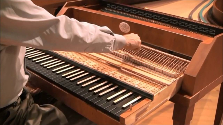 Close-up of a hand on the exposed action of an early keyboard instrument